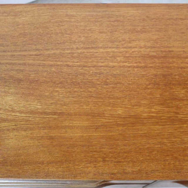 Smooth teak wood grain surface of vintage British mid-century sideboard with warm honey tones.