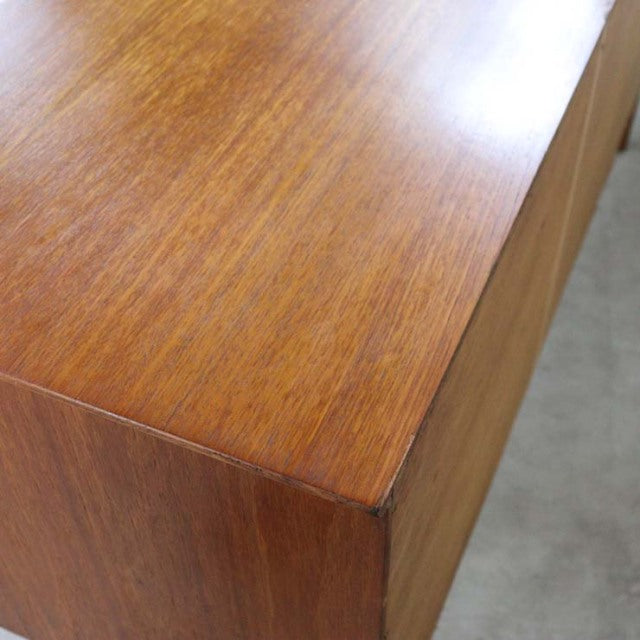 Close-up of vintage British mid-century teak sideboard corner showing smooth wood grain and clean, sharp edges.