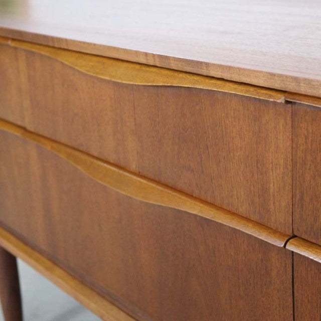 Mid-century British vintage teak sideboard by Austinsuite with smooth wood grain and curved drawer fronts.
