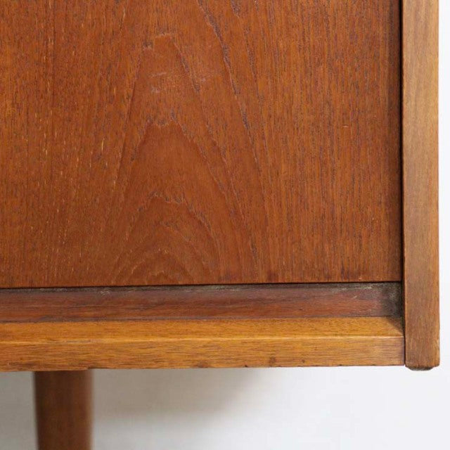 Close-up of vintage British mid-century teak sideboard corner showing rich wood grain and smooth finish.