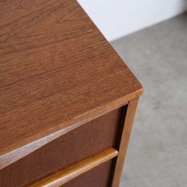 Close-up of vintage British mid-century teak sideboard corner showing rich wood grain and smooth craftsmanship.