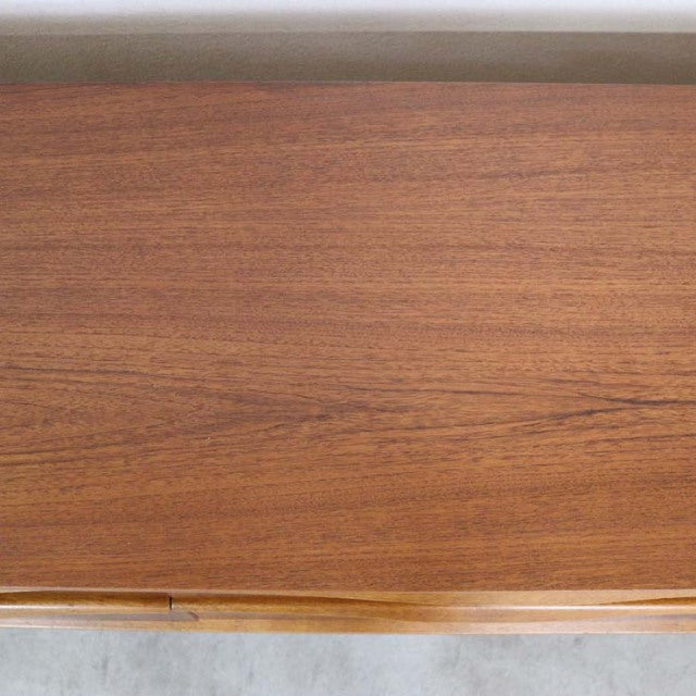 Close-up of vintage teak wood grain on British mid-century Austinsuite sideboard surface with warm natural tones.