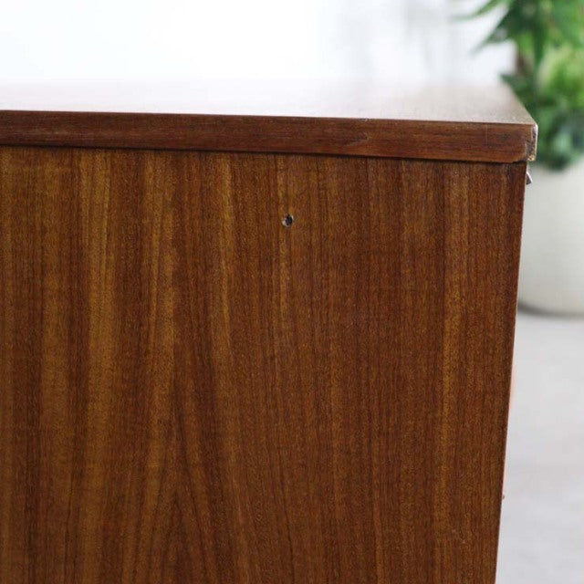 Close-up of vintage British mid-century teak sideboard panel showing rich wood grain and smooth finish.