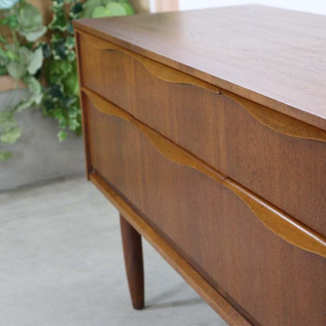 Mid-century British vintage teak sideboard by Austinsuite with smooth wood grain and tapered legs.