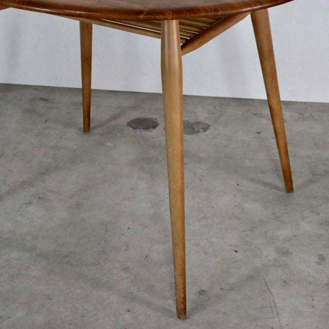 Mid-century British vintage teak dining table with tapered legs and visible wood grain.