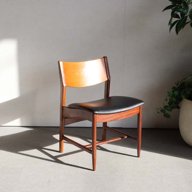 Mid-century British vintage teak dining chair with tapered legs and black cushioned seat, Danish-inspired design.