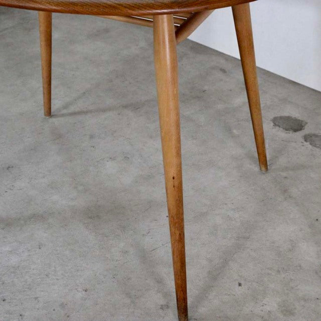 Mid-century vintage British ERCOL breakfast table leg made of teak with smooth, tapered design and visible wood grain.