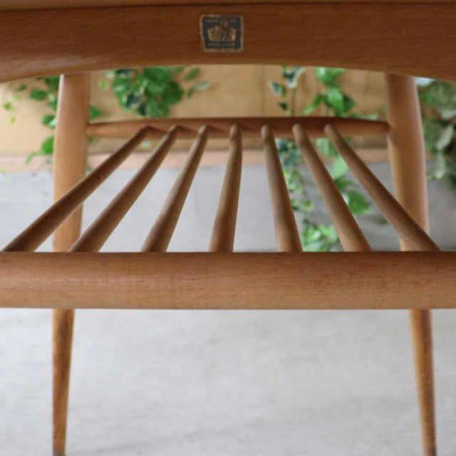 Vintage mid-century British teak breakfast table by ERCOL with spindle shelf and tapered legs.