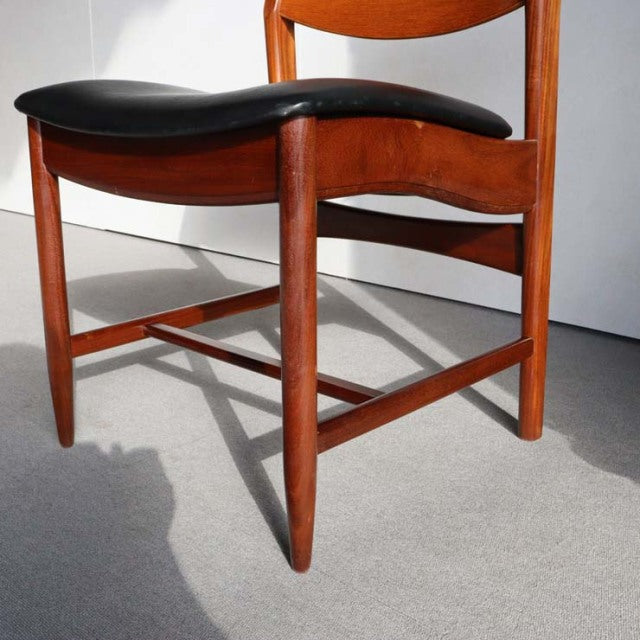 Mid-century British vintage teak dining chair with curved backrest and black leather seat cushion, smooth wood grain and.