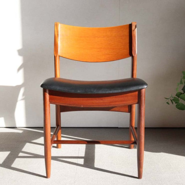 Mid-century British vintage teak dining chair with black leather seat and curved backrest.