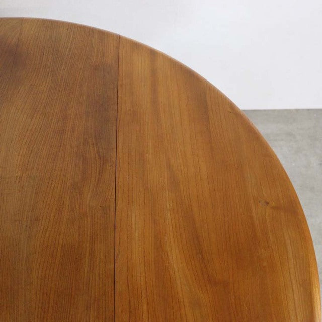 Mid-century British vintage Ercol dining table in teak with smooth grain and rounded drop-leaf edge.