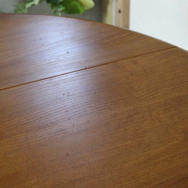 Vintage British mid-century Ercol teak dining table top showing smooth grain and drop-leaf joint detail.