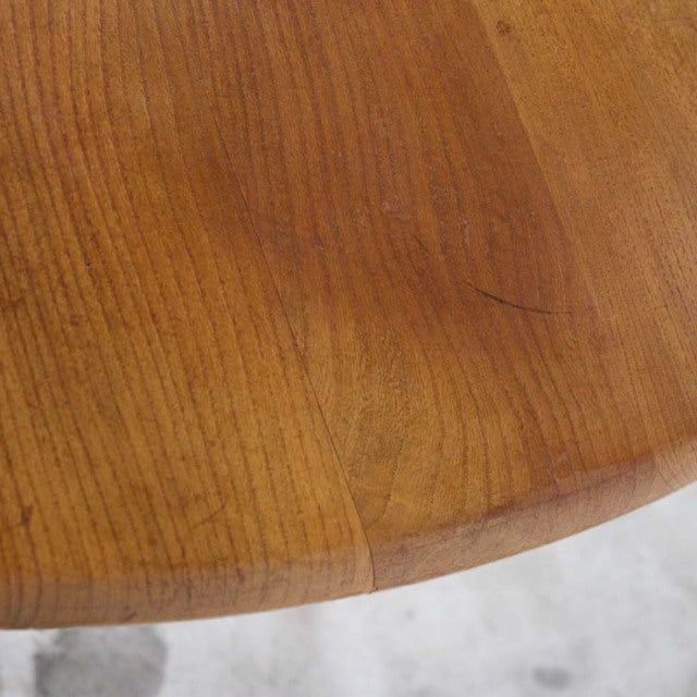 Close-up of vintage British mid-century Ercol teak dining table top showing warm wood grain and smooth rounded edge.