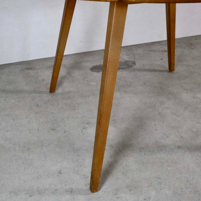 Mid-century British Ercol dining table leg in warm teak with tapered design and visible wood grain on concrete floor.
