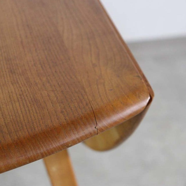 Close-up of vintage British mid-century teak drop-leaf dining table corner showing smooth wood grain and rounded edges.