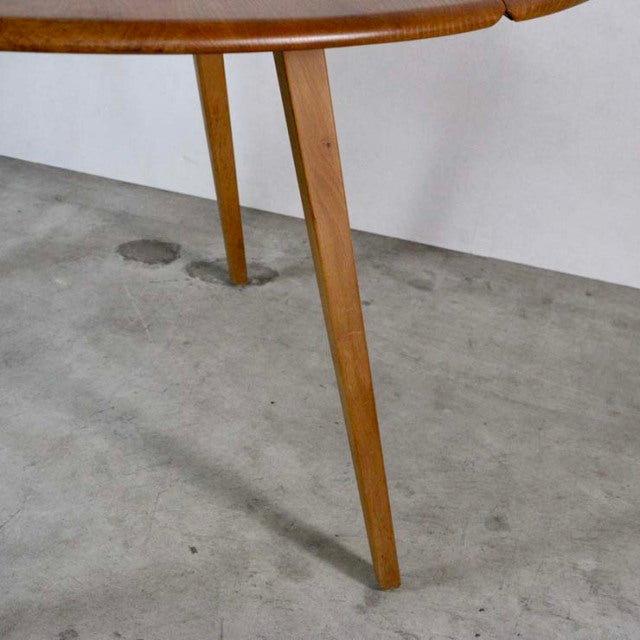 Mid-century British vintage Ercol dining table in teak with tapered round legs and drop-leaf design.