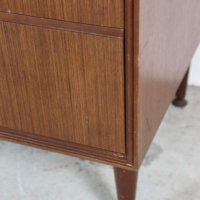 Mid-century British vintage teak chest leg showing rich wood grain and tapered cylindrical foot with rounded base.