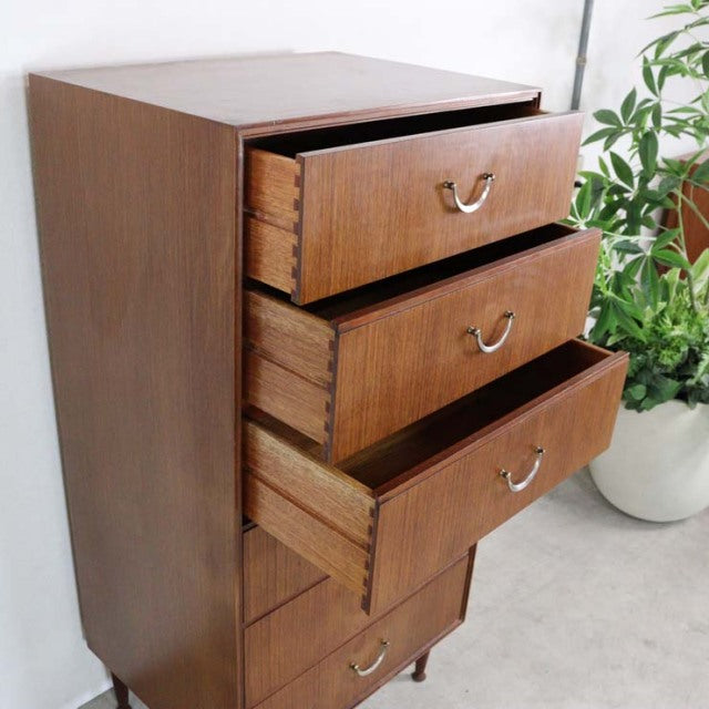 Vintage teak mid-century British six-drawer chest by Meredew featuring visible wood grain and curved metal handles.