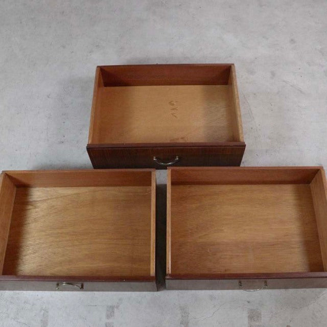 Three open teak drawers from a British mid-century vintage Meredew chest, showing wood grain and solid joinery.