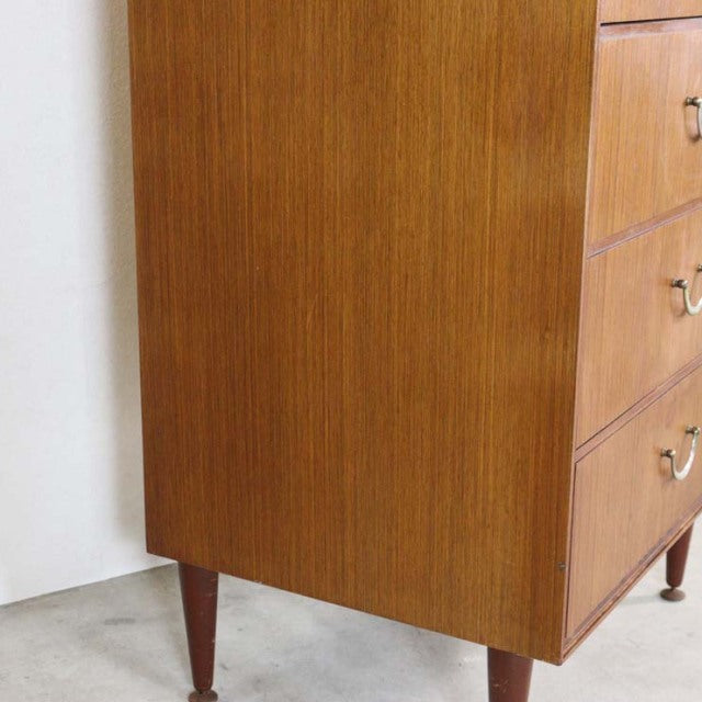 Vintage mid-century teak chest with six drawers, British design featuring tapered legs and rich wood grain from Denmark.