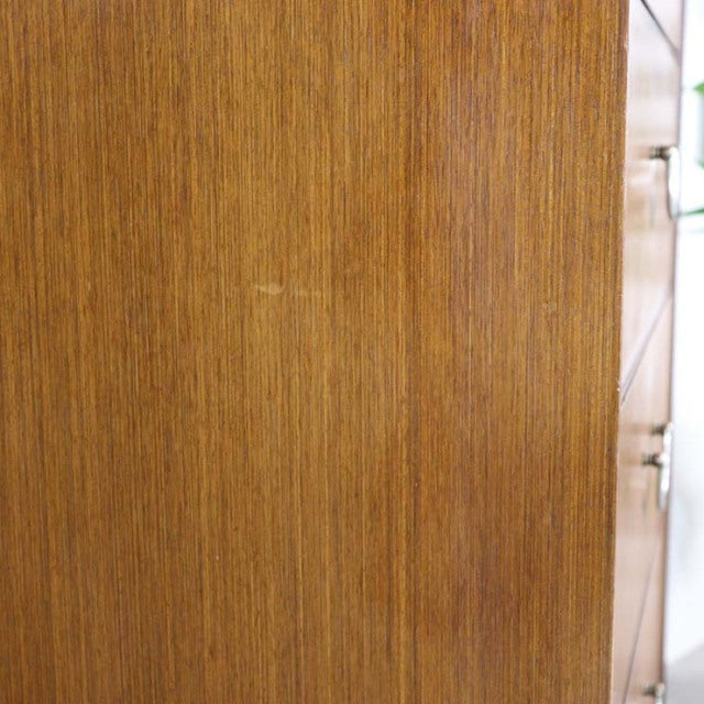 Close-up of vintage British mid-century teak chest side panel showing fine wood grain and smooth finish.