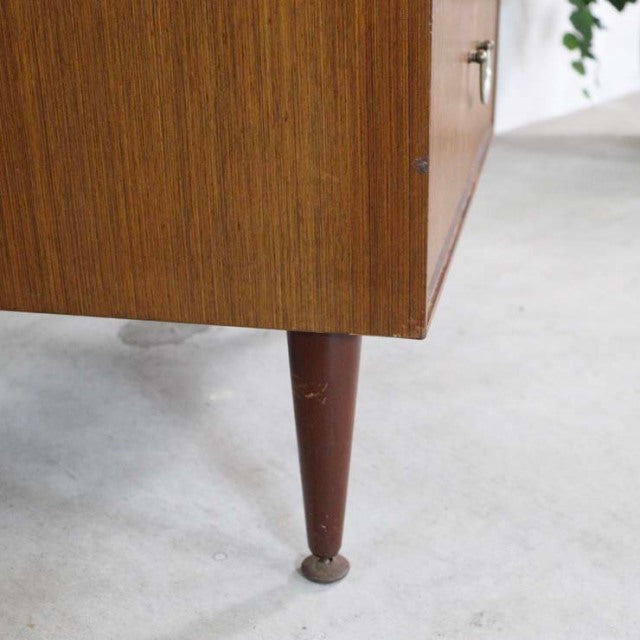 Mid-century British vintage teak chest leg with rich wood grain and tapered design on concrete floor.