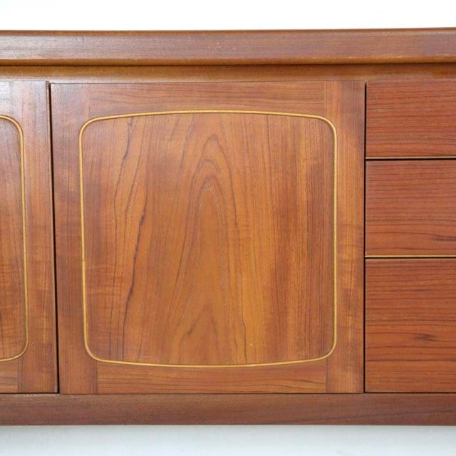 Vintage teak mid-century British sideboard by Nathan with curved square doors and natural wood grain detailing.