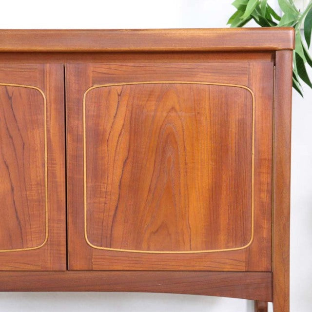 Mid-century British vintage teak sideboard by Nathan with rich wood grain and rounded square panel doors.