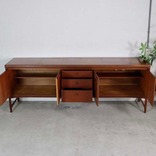 Mid-century British vintage teak sideboard by Nathan with three drawers, open hinged doors, and clean wood grain finish.