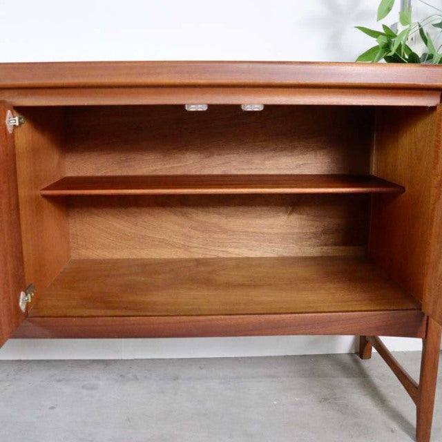 Open teak wood vintage mid-century British sideboard by Nathan with visible wood grain and a single interior shelf.
