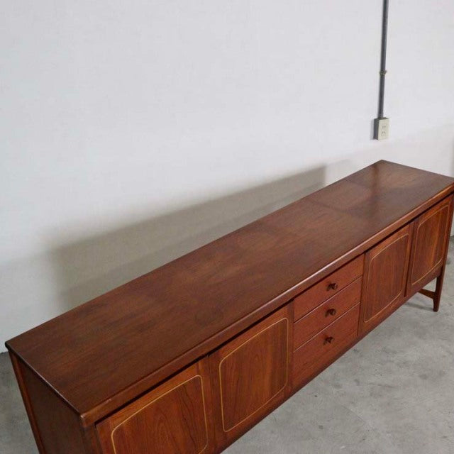 Mid-century British vintage teak sideboard by Nathan with rich wood grain, sliding doors, and tapered legs.