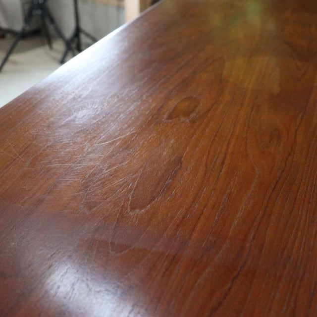 Close-up of vintage teak sideboard top showcasing warm wood grain and smooth mid-century British design by Nathan.