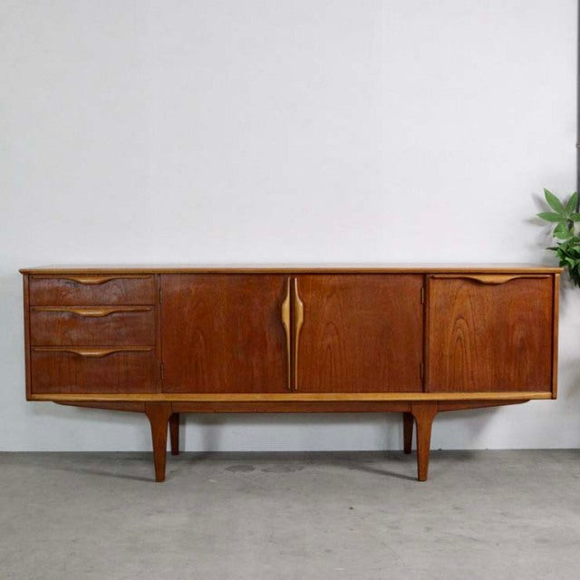 Mid-century British vintage teak sideboard by Jentique with rich wood grain, curved handles, and tapered legs.