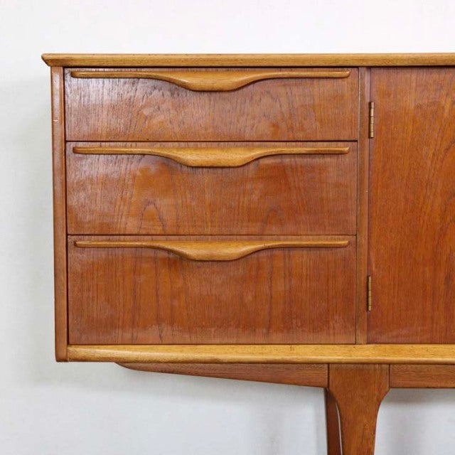 Mid-century British vintage teak sideboard by Jentique with sculpted drawer handles and sleek wood grain.