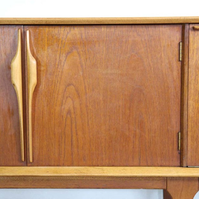 Mid-century British vintage teak sideboard door with sculpted vertical wooden handles and rich wood grain detailing.