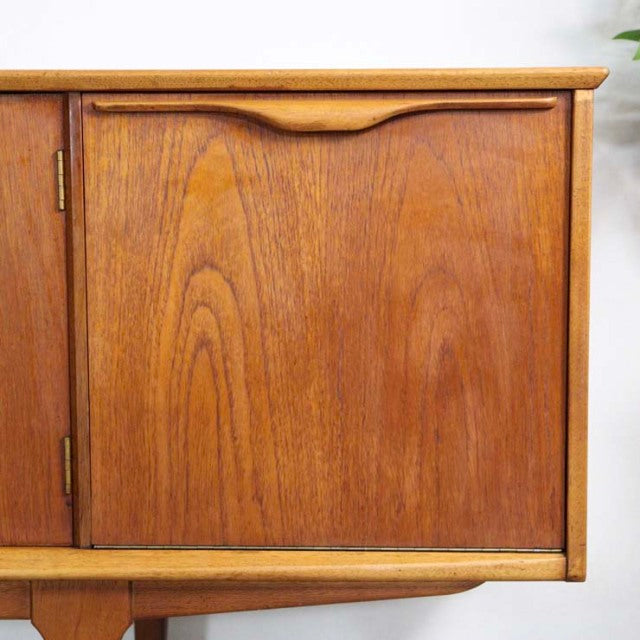 Mid-century teak sideboard door panel with visible wood grain and rounded edge detail, British vintage style.