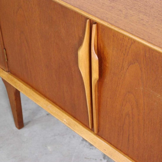 Mid-century British vintage teak sideboard by Jentique with distinctive sculpted wooden handles and tapered legs.