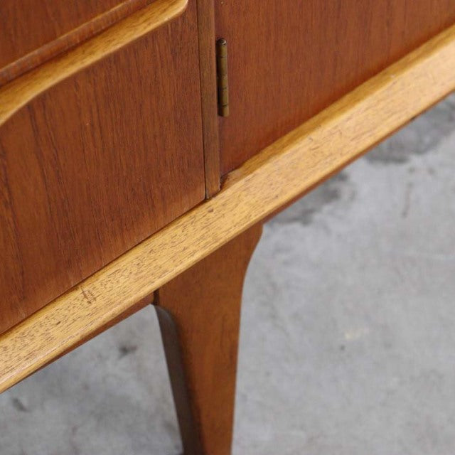 Mid-century vintage teak sideboard leg with warm wood grain and tapered British-Danish design detail.
