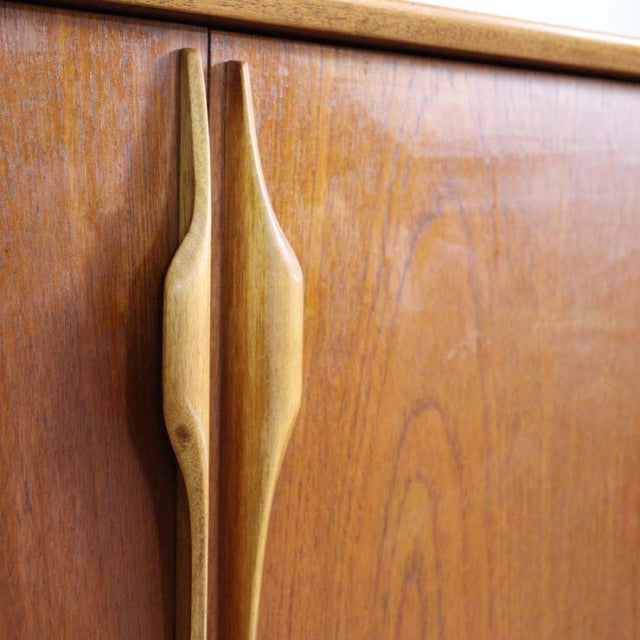 Close-up of vintage Jentique teak sideboard door handles showcasing wood grain and mid-century British design from Denmark.