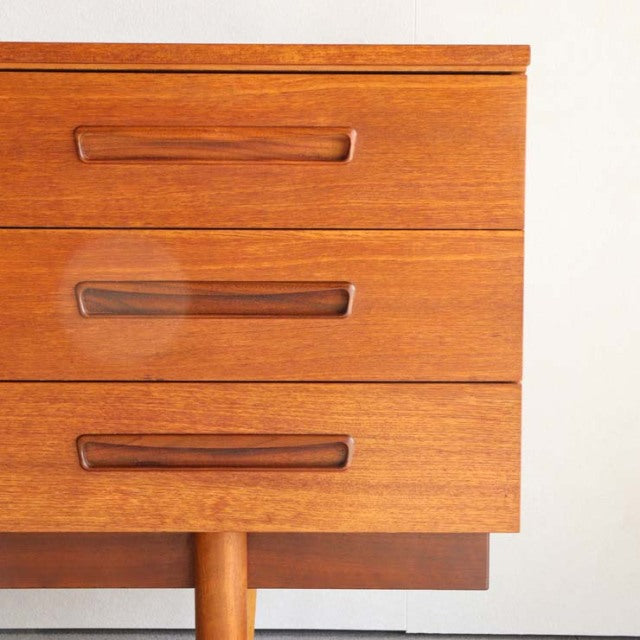 Mid-century vintage teak sideboard drawers with smooth wood grain and sleek recessed handles from British-Denmark design.
