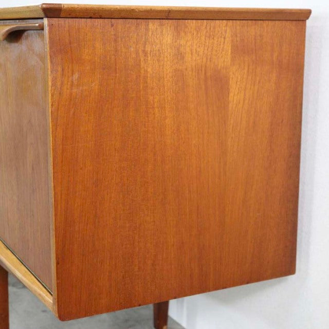 Mid-century British teak sideboard by Jentique with smooth wood grain and tapered legs.