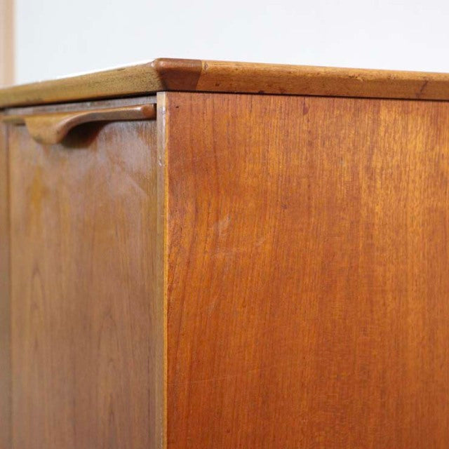 Mid-century British vintage teak sideboard corner with smooth wood grain and rounded edge detailing.