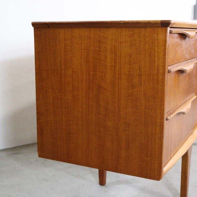 Mid-century British vintage teak sideboard by Jentique with smooth wood grain and tapered legs.
