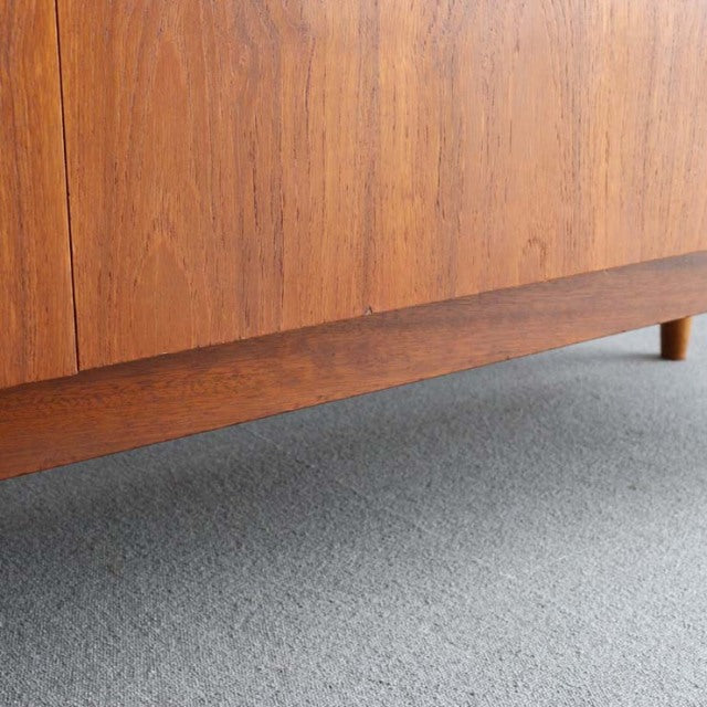Mid-century vintage teak sideboard with smooth wood grain and tapered British Denmark-style legs.