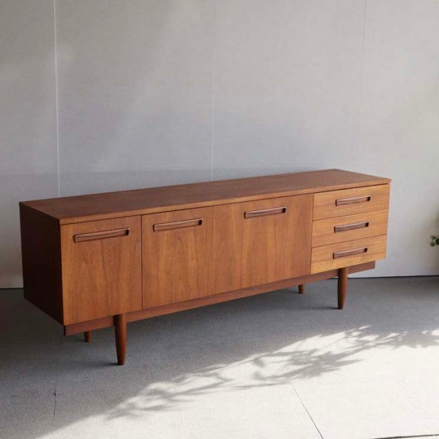 Mid-century vintage teak sideboard with rich wood grain, British-Denmark style, featuring four doors and three drawers on.