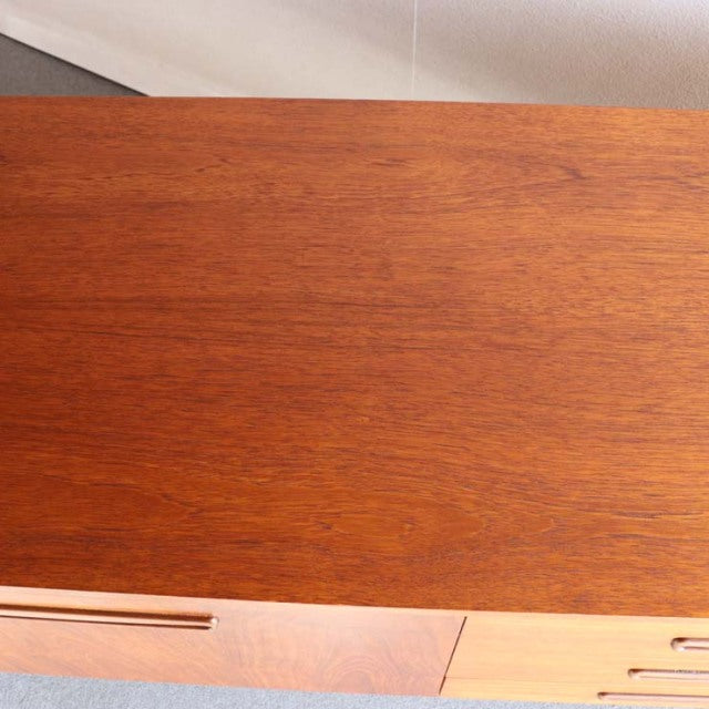 Vintage teak sideboard top panel showcasing rich wood grain with warm mid-century British and Danish design influences.