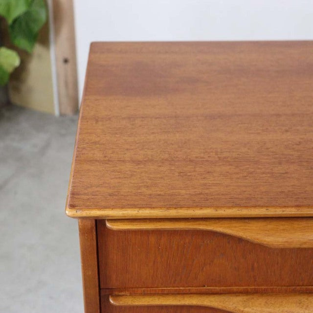 Mid-century British teak sideboard corner showing rich wood grain and smooth finish.