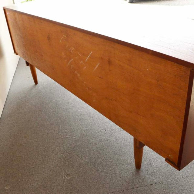 Mid-century vintage teak sideboard with visible wood grain and tapered legs, British-Denmark design style.
