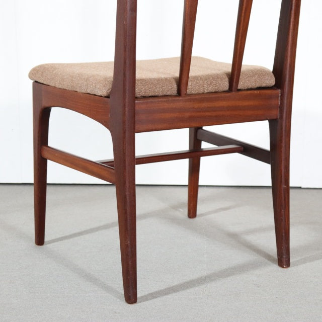 Mid-century British vintage teak dining chair by Younger, slender tapered legs, beige fabric seat, smooth wood grain visible.