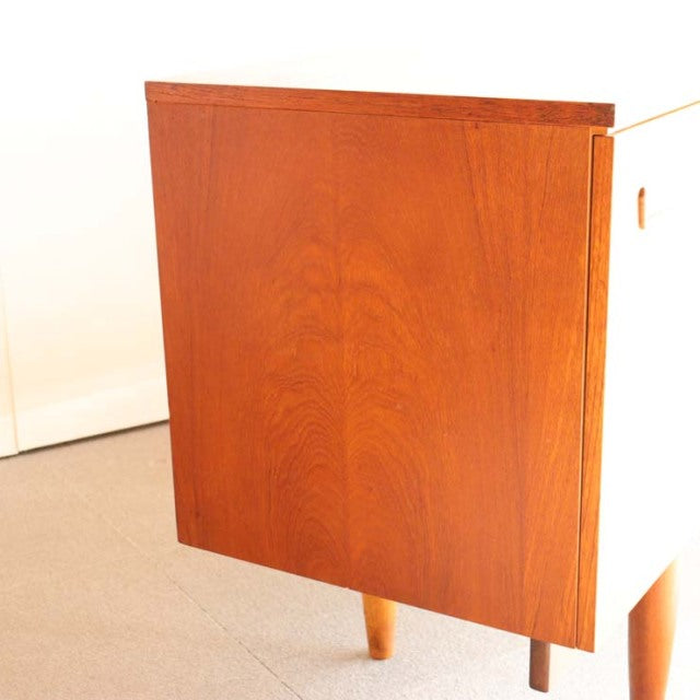 Vintage teak sideboard with rich wood grain, tapered mid-century British legs, Danish design influence.